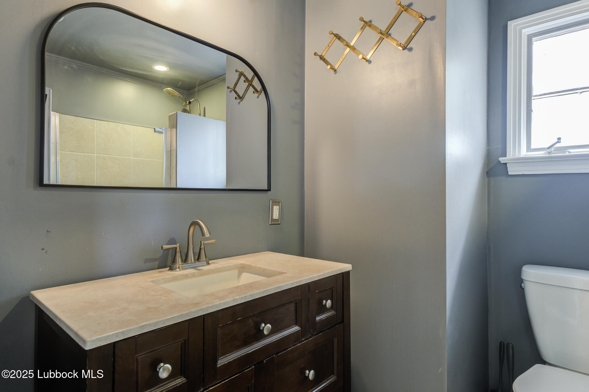 3309 22nd Street Lubbock, TX 79410 - Photo 23 of 37 a bathroom with a sink vanity mirror and toilet