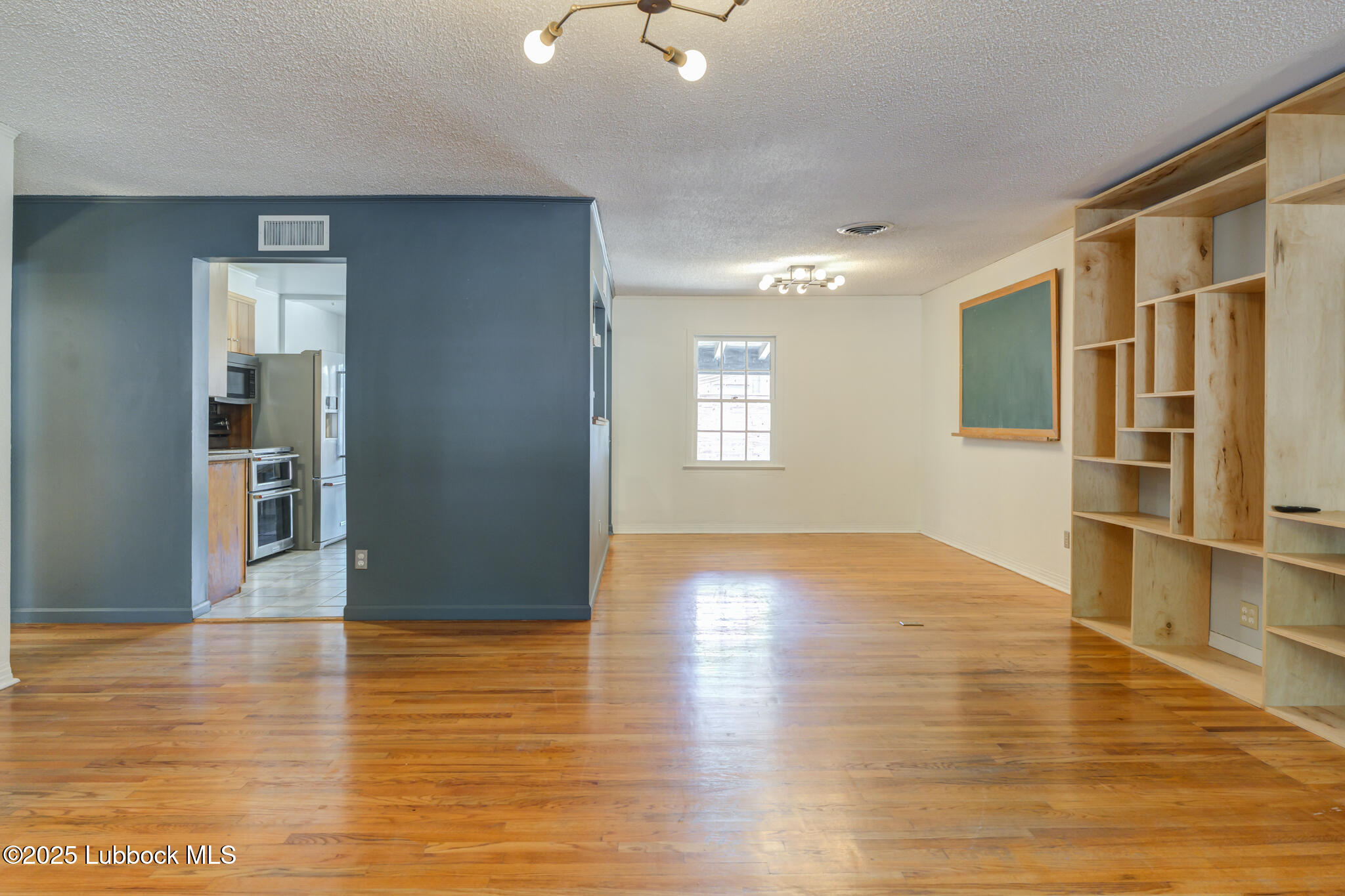 3309 22nd Street Lubbock, TX 79410 - Photo 4 of 37 a view of an empty room with window and wooden floor
