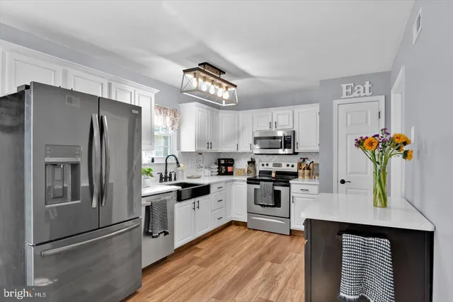 a kitchen with stainless steel appliances granite countertop a refrigerator stove and microwave
