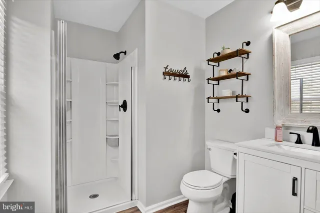 a bathroom with a granite countertop sink a toilet and shower