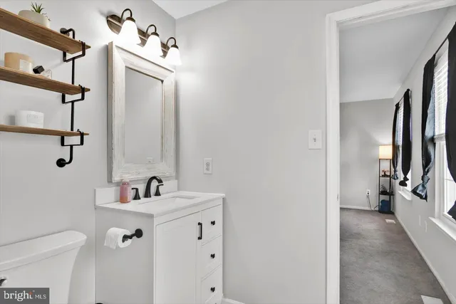 a bathroom with a toilet sink vanity and shower