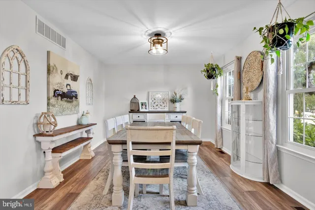 a view of a dining room with furniture a chandelier and wooden floor