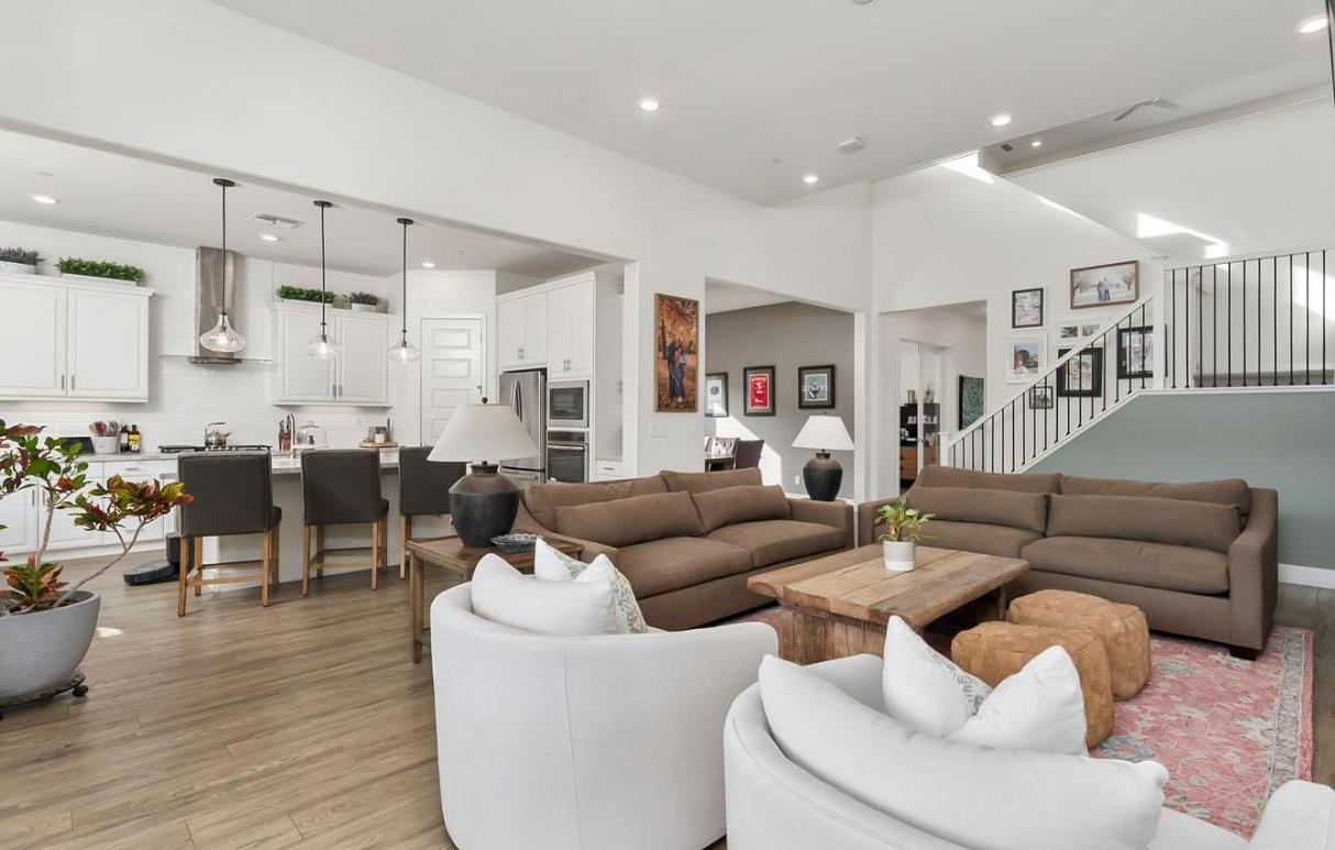 1509 Harvest Loop Folsom, CA 95630 - Photo 88 of 92 THE MAIN LOUNGE embodies soaring ceilings embraced by a series of transom windows, flooding the open communal floor plan with tons of natural light. This entire home is LIGHT, BRIGHT AND AIRY! Added to the exquisite design are the stunning, super durable water and scratch proof wide board luxury vinyl plank flooring. Despite its spacious square feet, the central lounge and dining room are still one of the most charming shared areas of the residence, featuring the cast concrete fireplace and mantel, triple transom windows, and adjacent double door den/study/office/salon flex space....breath taking!