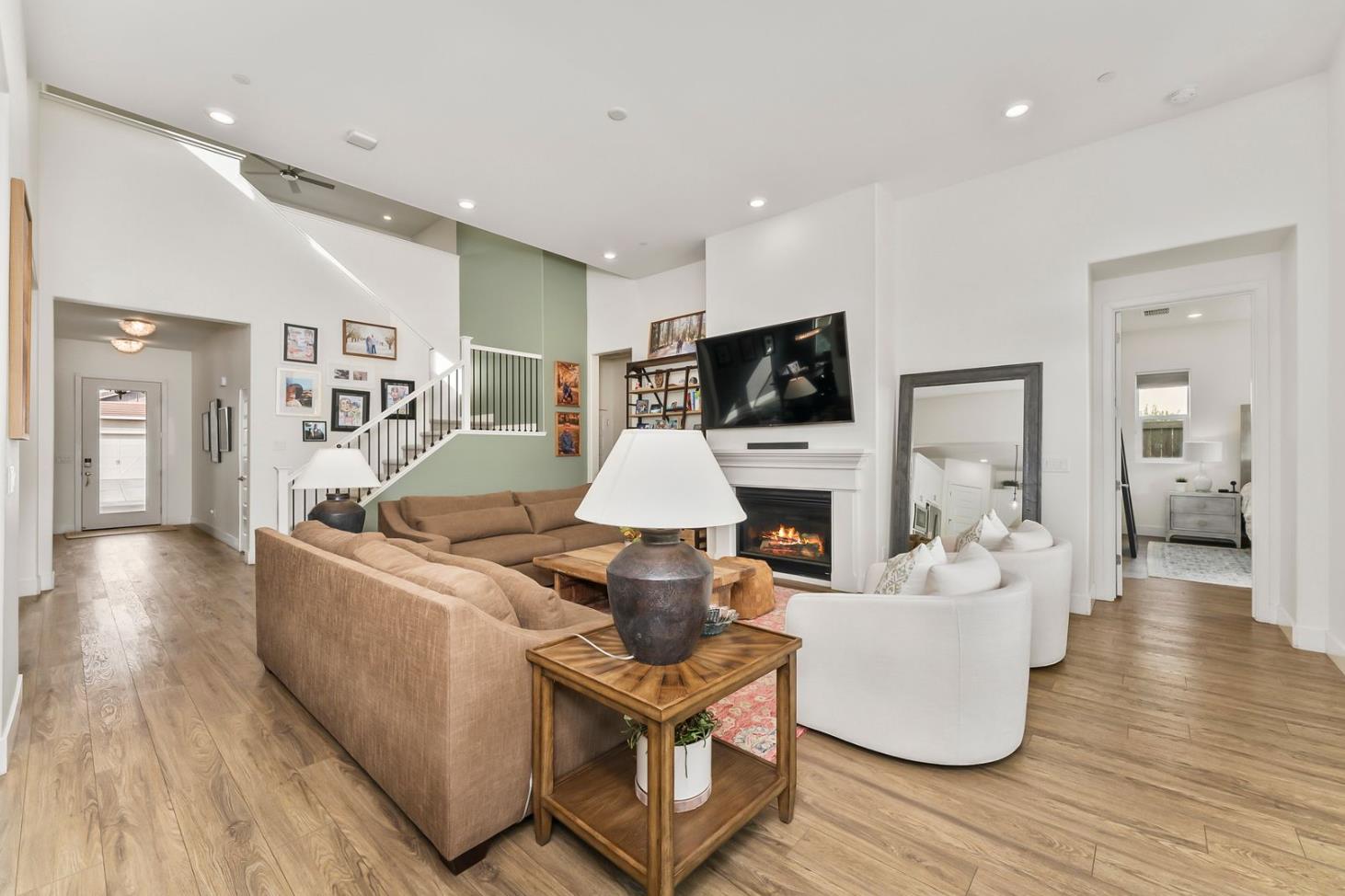 1509 Harvest Loop Folsom, CA 95630 - Photo 89 of 92 THE MAIN LOUNGE embodies soaring ceilings embraced by a series of transom windows, flooding the open communal floor plan with tons of natural light. This entire home is LIGHT, BRIGHT AND AIRY! Added to the exquisite design are the stunning, super durable water and scratch proof wide board luxury vinyl plank flooring. Despite its spacious square feet, the central lounge and dining room are still one of the most charming shared areas of the residence, featuring the cast concrete fireplace and mantel, triple transom windows, and adjacent double door den/study/office/salon flex space....breath taking!