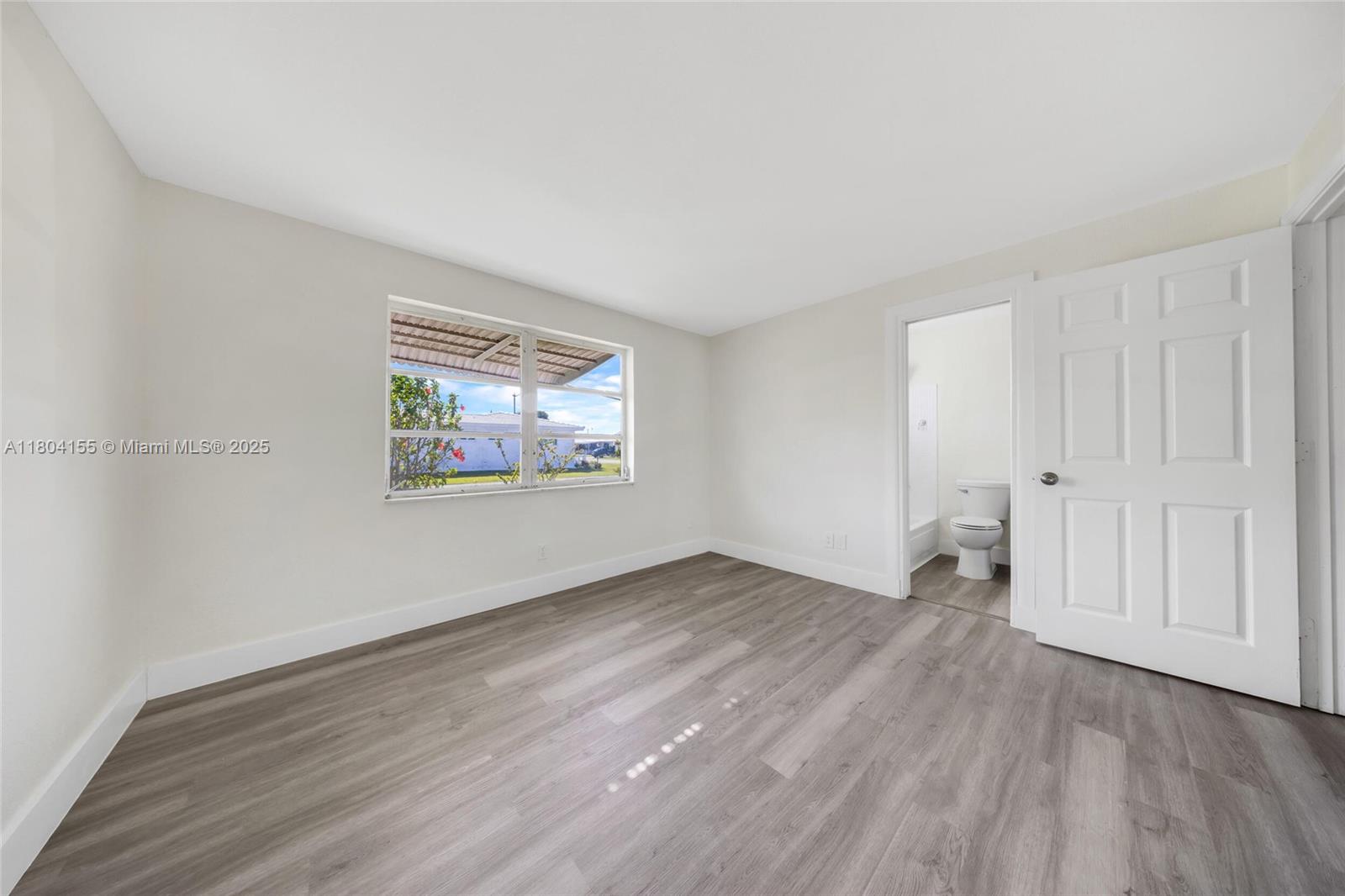 2520 Northwest 2nd Drive Pompano Beach, FL 33064 - Photo 14 of 20 an empty room with wooden floor and windows