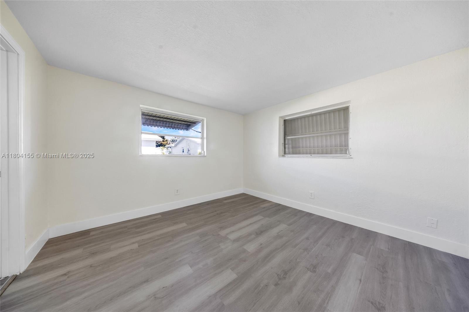 2520 Northwest 2nd Drive Pompano Beach, FL 33064 - Photo 16 of 20 an empty room with wooden floor and windows