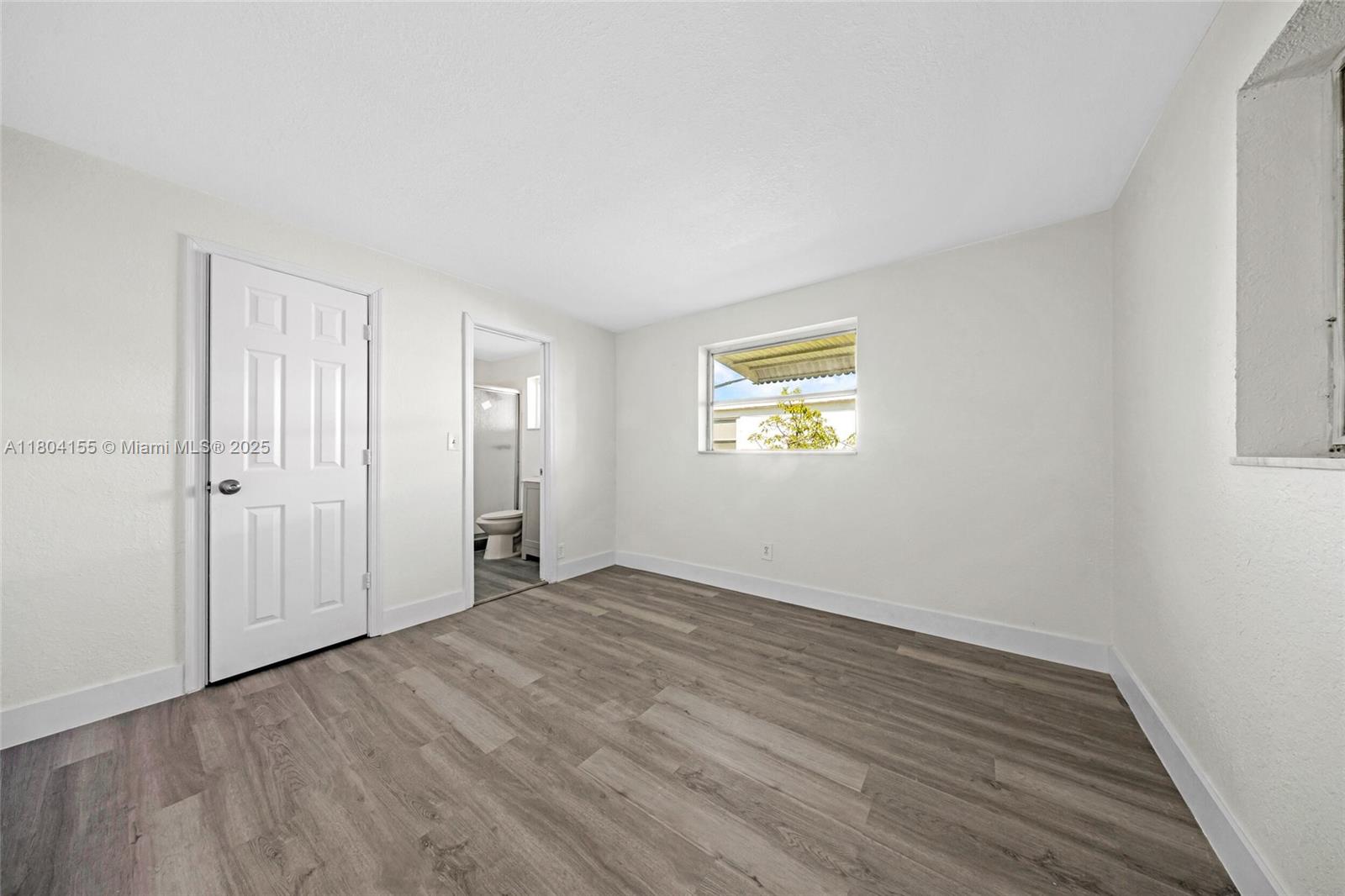 2520 Northwest 2nd Drive Pompano Beach, FL 33064 - Photo 17 of 20 a view of an empty room with wooden floor and a window