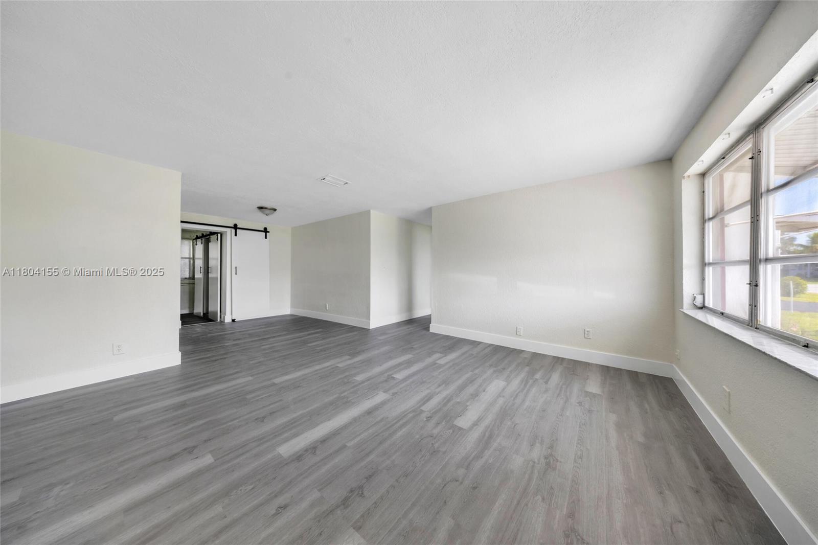 2520 Northwest 2nd Drive Pompano Beach, FL 33064 - Photo 2 of 20 wooden floor in an empty room with a window
