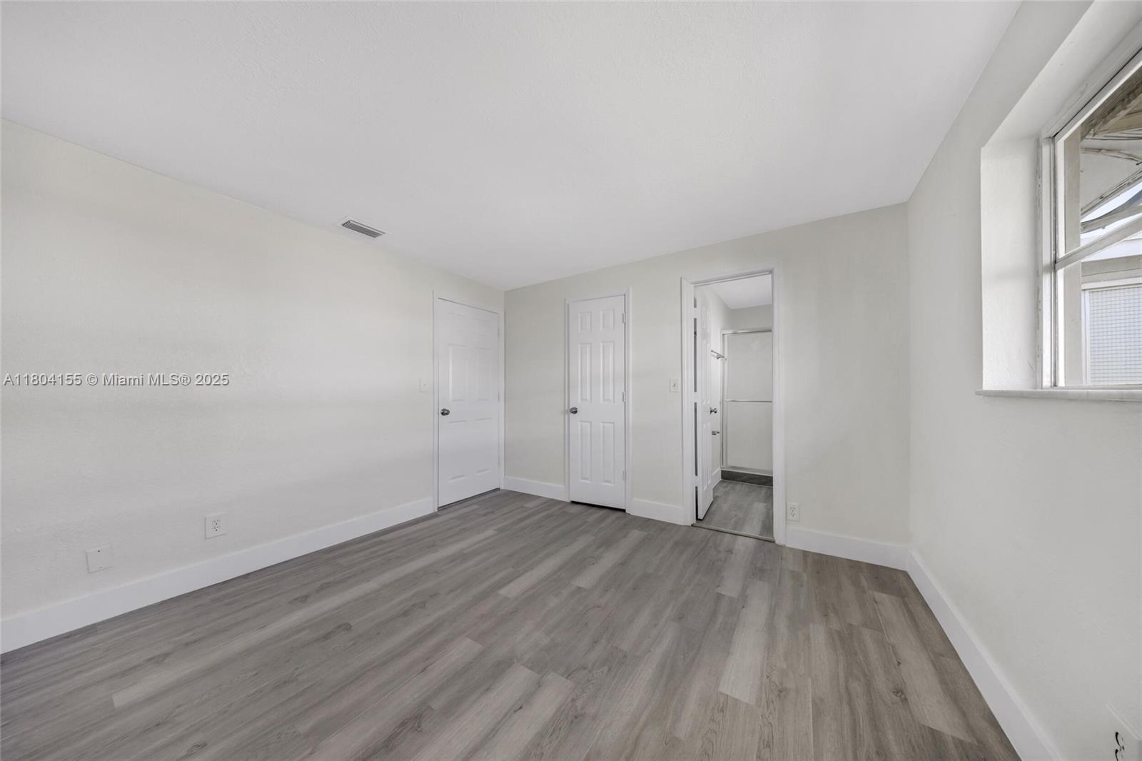 2520 Northwest 2nd Drive Pompano Beach, FL 33064 - Photo 7 of 20 a view of an empty room with wooden floor and a window