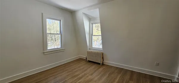 an empty room with wooden floor and a window