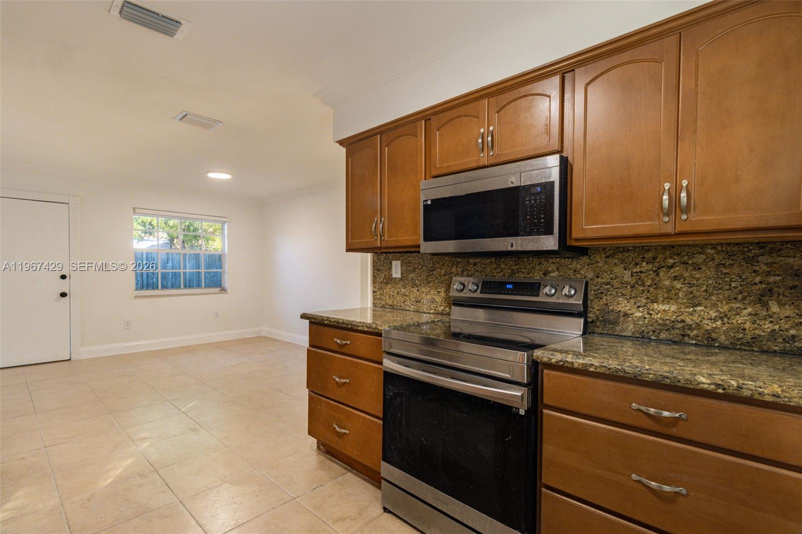 1518 Northwest 65th Street Miami, FL 33147 - Photo 11 of 28 a kitchen with stainless steel appliances granite countertop a stove a microwave and a sink