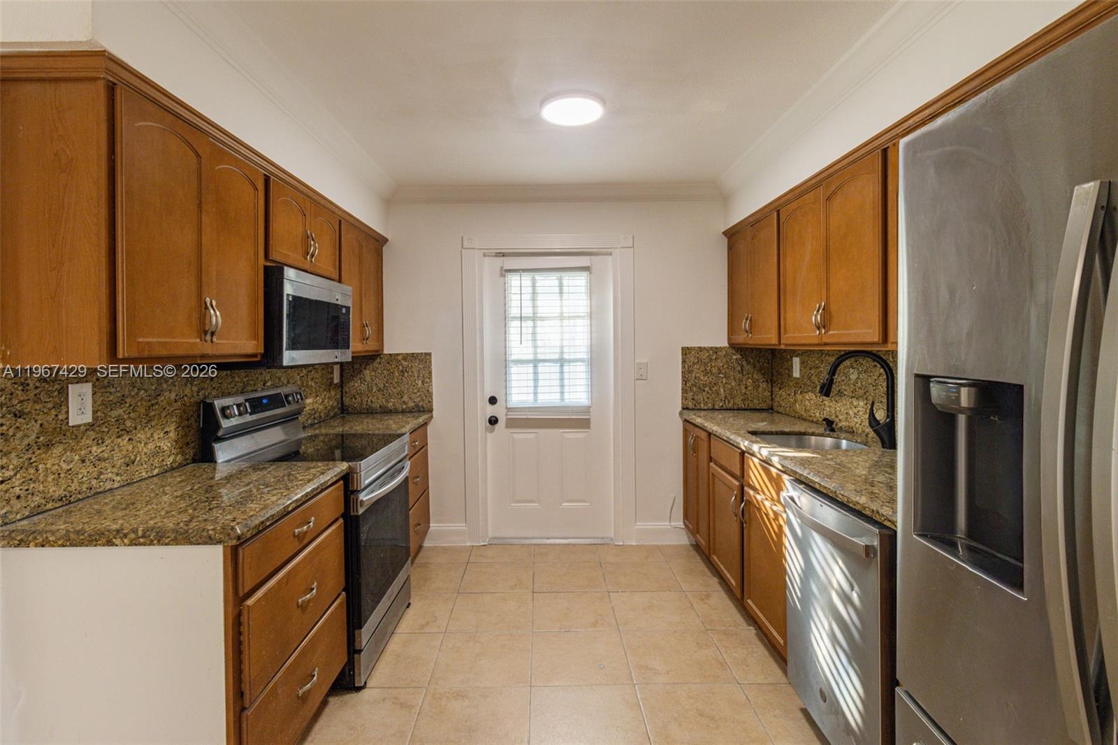 1518 Northwest 65th Street Miami, FL 33147 - Photo 10 of 28 a kitchen with stainless steel appliances granite countertop a stove top oven a sink dishwasher a refrigerator and a microwave