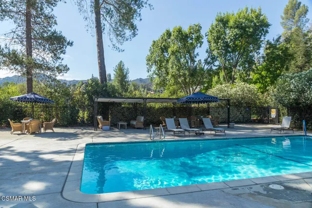 a view of a backyard with table and chairs under an umbrella
