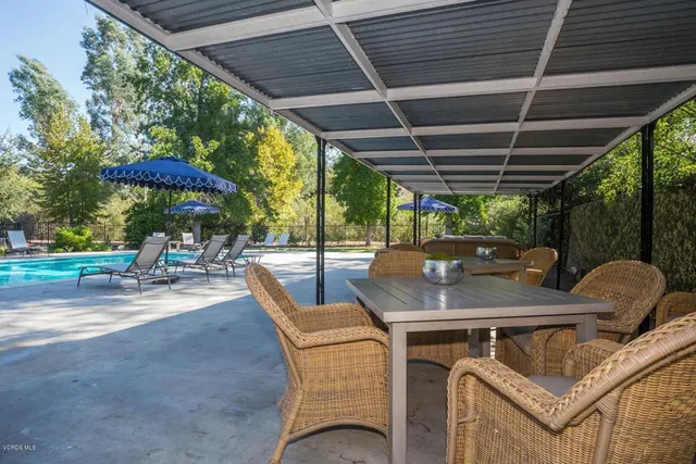 a view of a patio with a table chairs and a barbeque