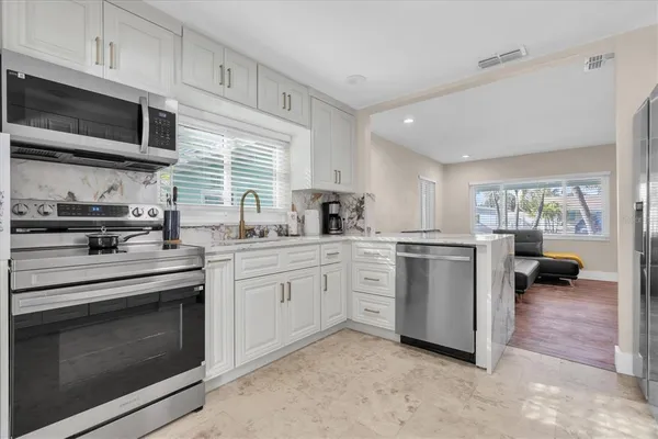 a kitchen with appliances a sink and cabinets