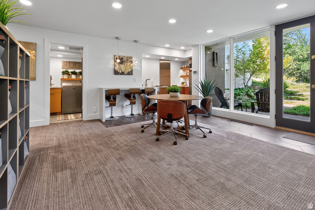 11454 South Oberland Road Sandy, UT 84092 - Photo 45 of 103 Recessed lighting illuminates the open-concept space, featuring a built-in shelving unit, a breakfast bar, and a dining area with a round table