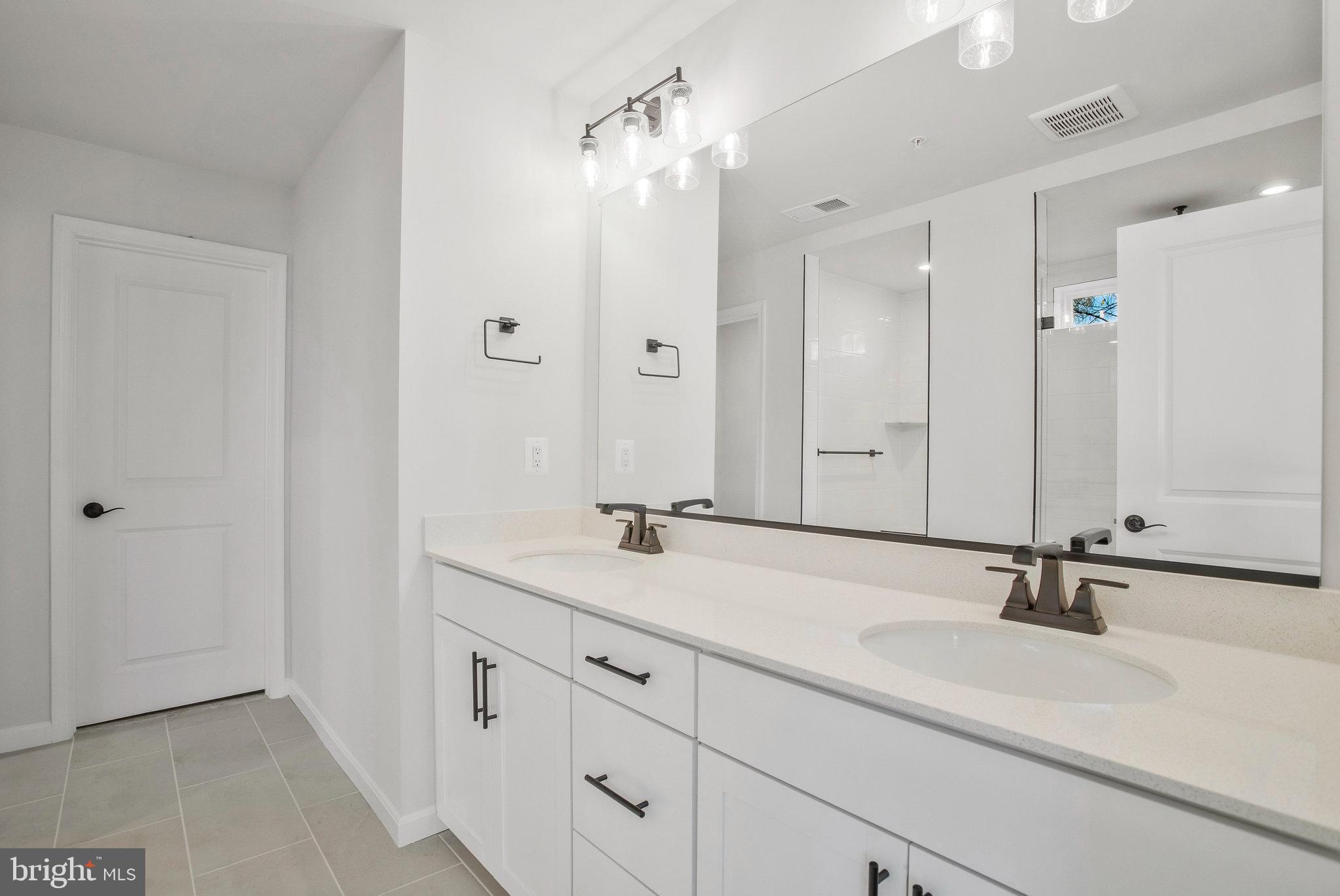 5 Brooks Nolen Way Owings Mills, MD 21117 - Photo 38 of 76 a bathroom with a sink and mirror with shower