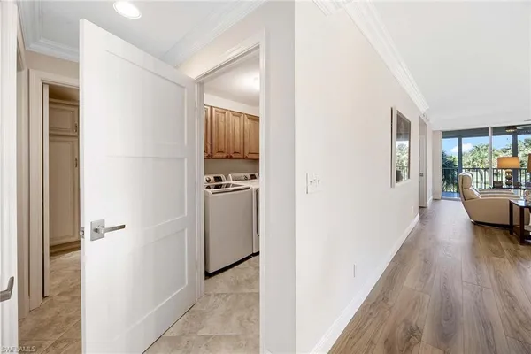 a view of a hallway with wooden floor and furniture
