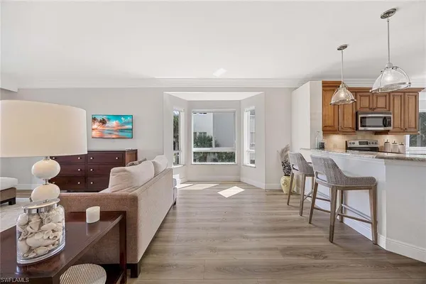 a living room with furniture a flat screen tv and a table