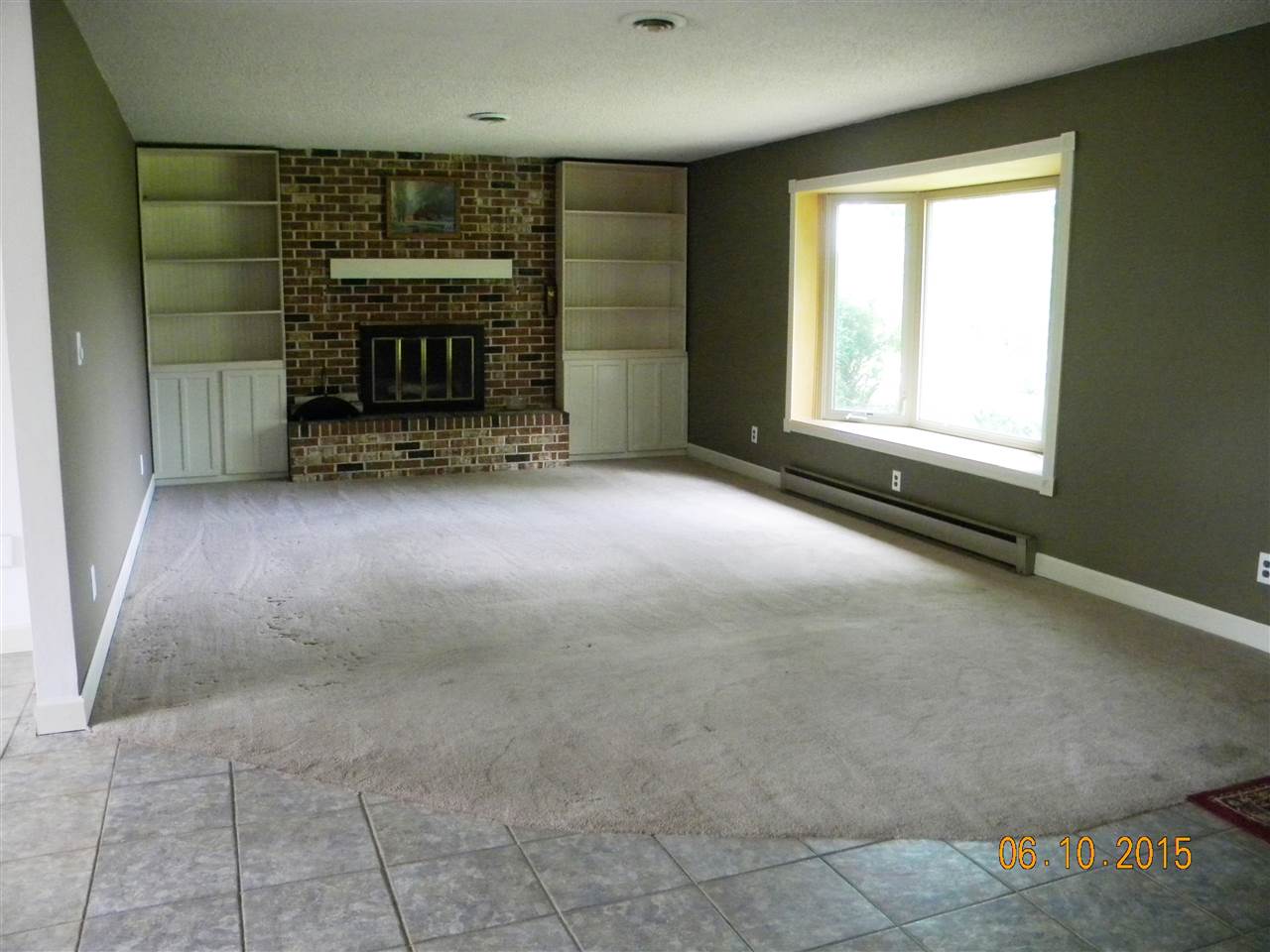 8105 Huber Road Belvidere, IL 61008 - Photo 5 of 20 an empty room with a fireplace and window