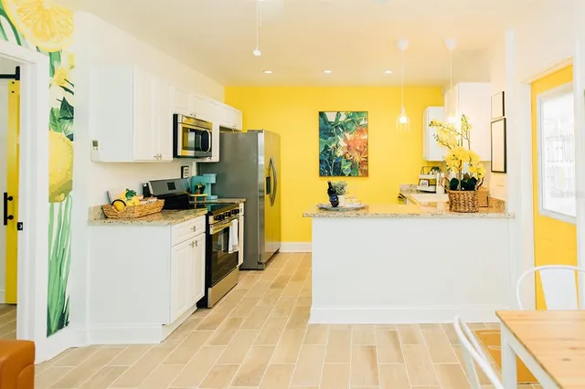 a large white kitchen with stainless steel appliances granite countertop a sink and cabinets