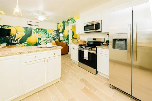 a kitchen with stainless steel appliances granite countertop a stove a sink and a refrigerator