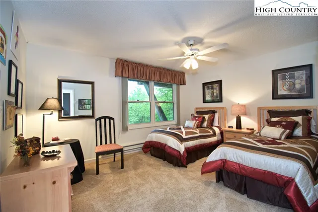 a bedroom with two beds and a chandelier