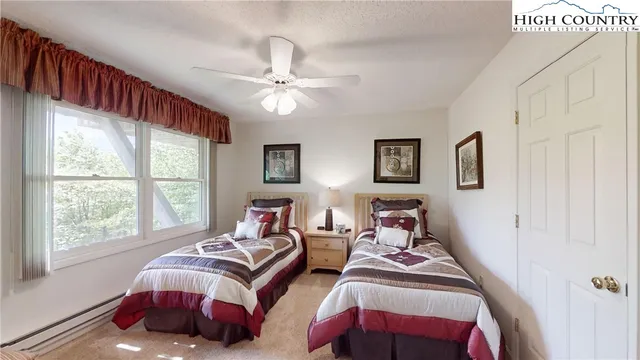 a bedroom with two beds and a window