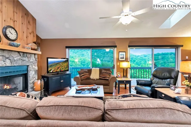 a living room with furniture a fireplace and a large window