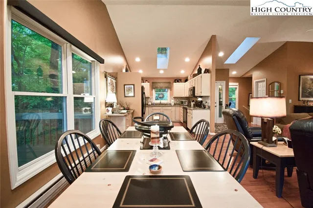 a room with furniture pool table and glass windows