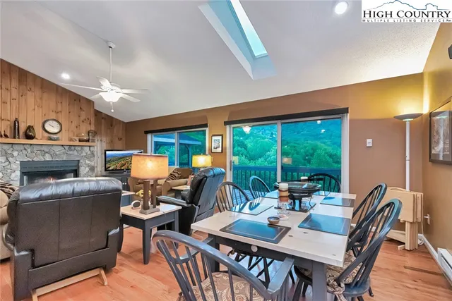 a dining room with furniture a fireplace and wooden floor