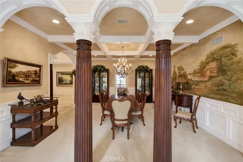 a kitchen with a dining table chairs sink and cabinets