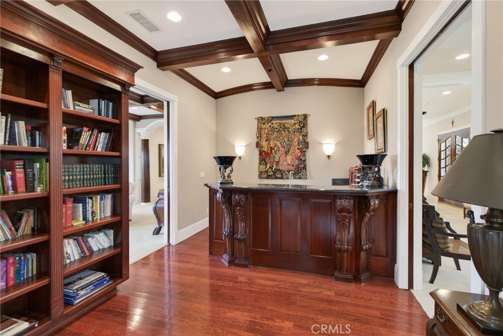 6952 Royal Hunt Ridge Drive Riverside, CA 92506 - Photo 22 of 75 a view of a hallway with bookshelf and wooden floor