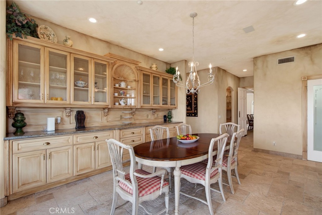 6952 Royal Hunt Ridge Drive Riverside, CA 92506 - Photo 29 of 75 a kitchen with a dining table chairs sink and cabinets