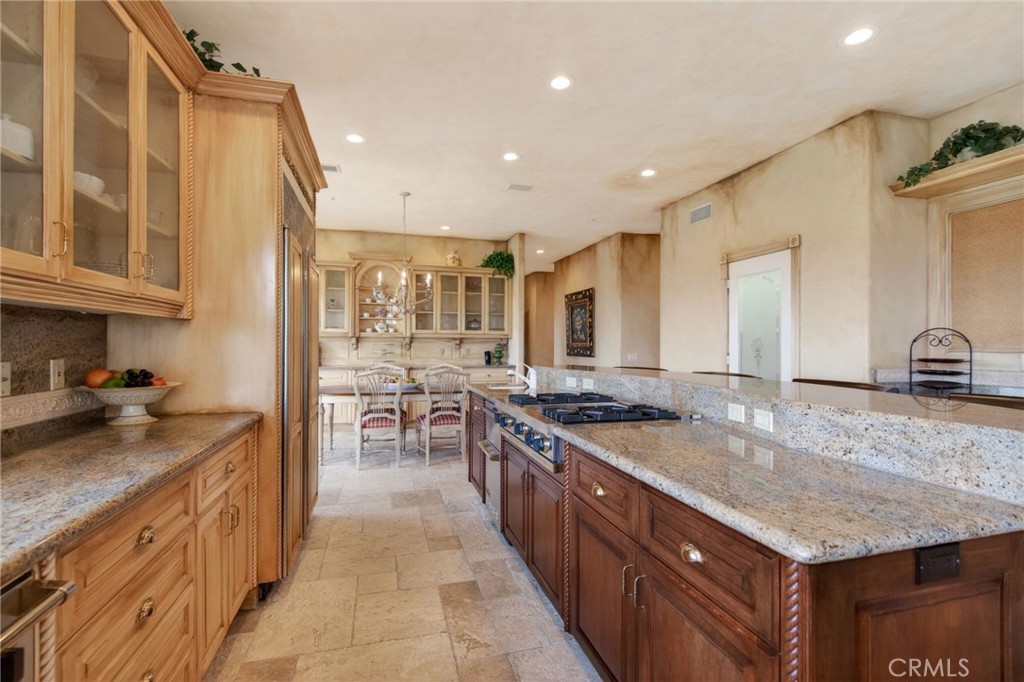 6952 Royal Hunt Ridge Drive Riverside, CA 92506 - Photo 31 of 75 a kitchen with stainless steel appliances granite countertop a sink stove and cabinets