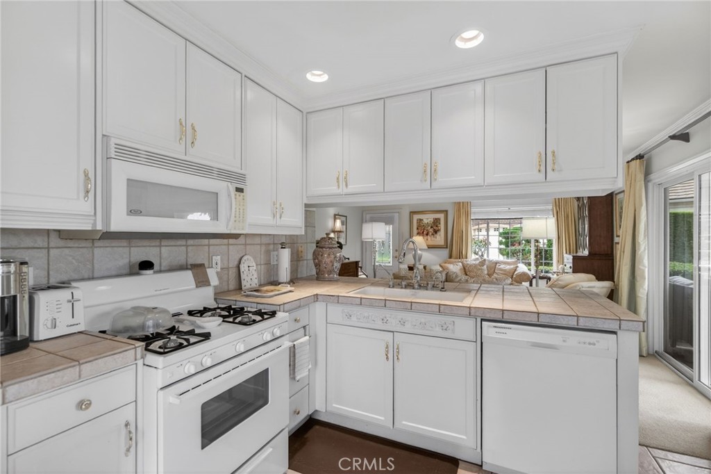 6952 Royal Hunt Ridge Drive Riverside, CA 92506 - Photo 69 of 75 a kitchen with granite countertop white cabinets and white appliances