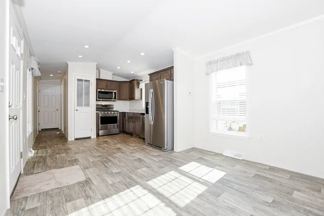 a view of kitchen with wooden floor electronic appliances and window