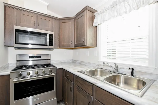 a kitchen with stainless steel appliances granite countertop a stove a refrigerator and a microwave