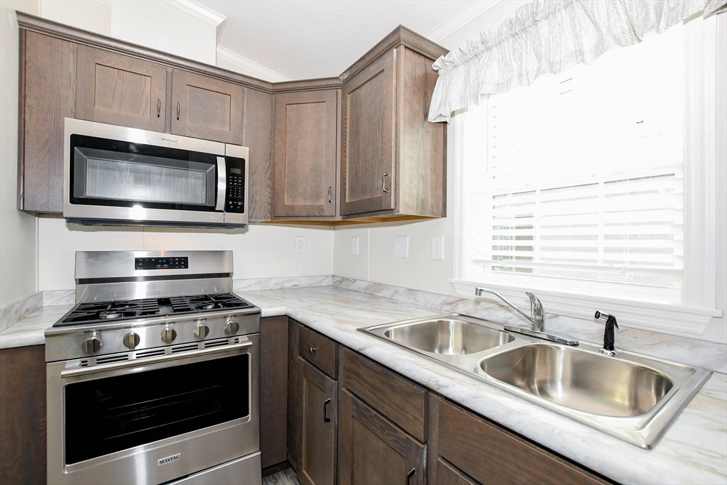 3040 Cranberry Highway, Unit 32 Wareham, MA 02538 - Photo 8 of 25 a kitchen that has a sink and a stove