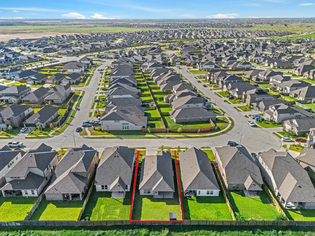 an aerial view of residential houses with outdoor space and swimming pool