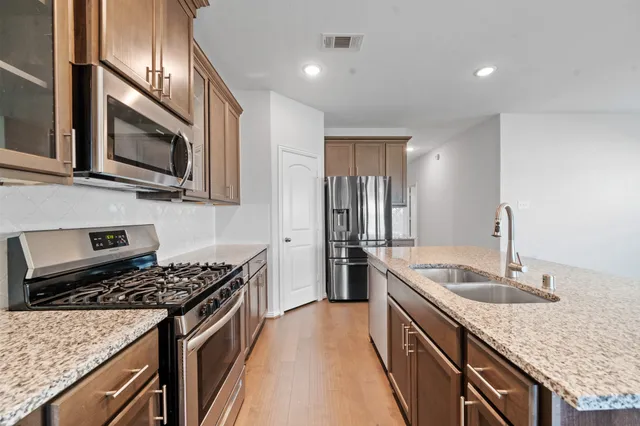 a kitchen with stainless steel appliances granite countertop a sink stove and refrigerator