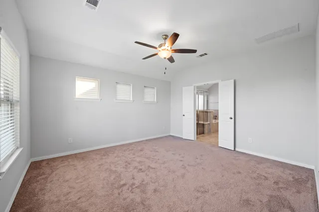 a view of empty room with a ceiling fan and a window