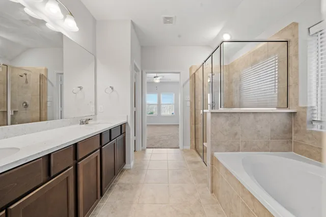 a bathroom with a tub sink and mirror