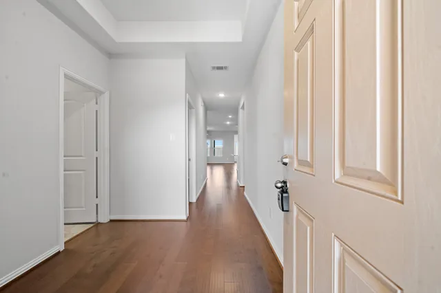 a view of a hallway with wooden floor