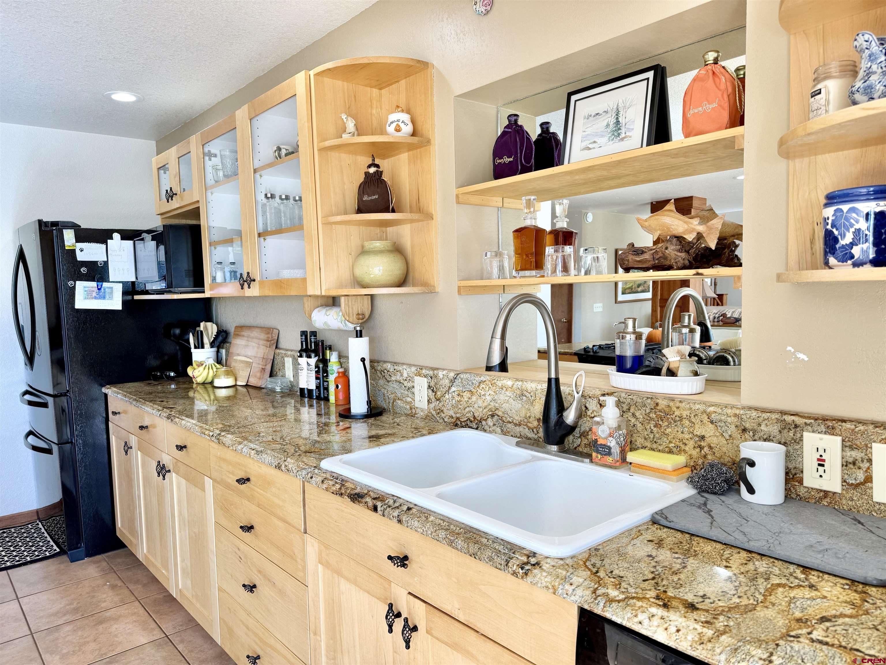 10528 Bostwick Park Road Montrose, CO 81401 - Photo 8 of 43 a kitchen with granite countertop a sink a stove and cabinets