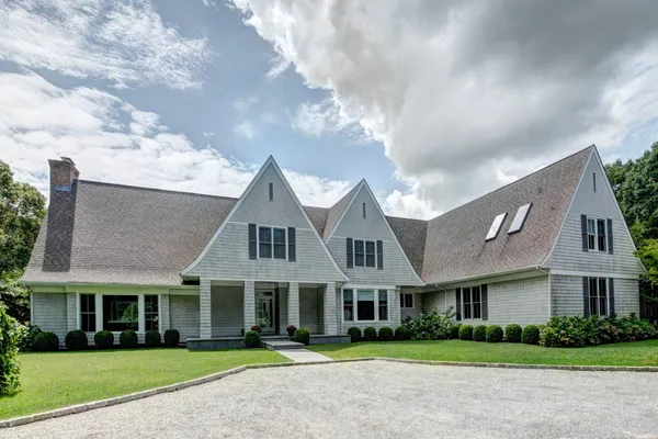 a front view of residential houses with yard and green space