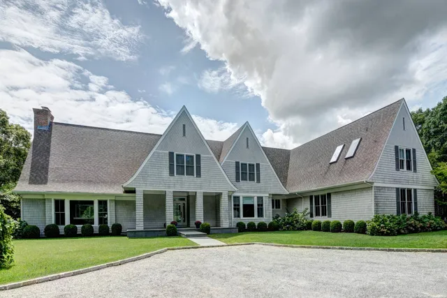 a front view of residential houses with yard and green space