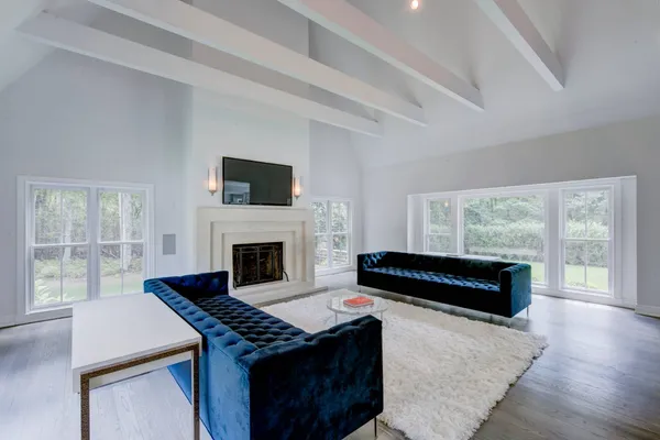 a living room with a fireplace a flat screen tv and a large window