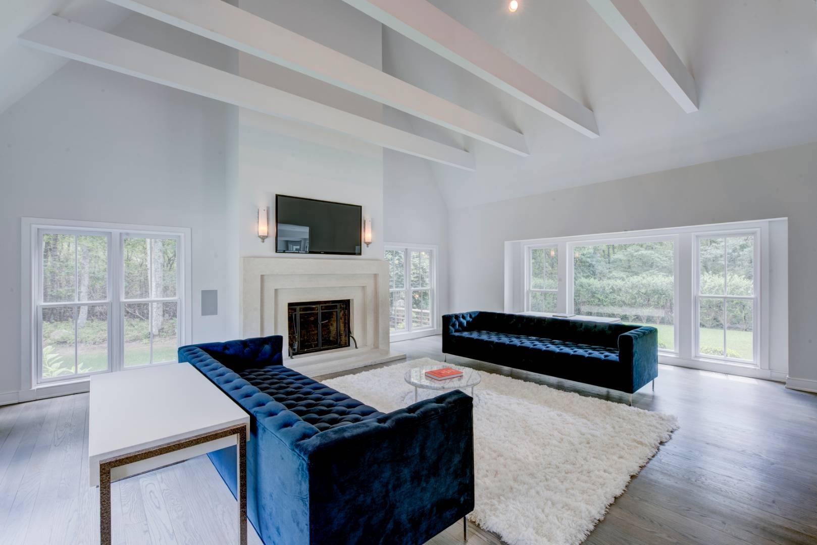 4 Paumanok Road Sag Harbor, NY 11963 - Photo 5 of 8 a living room with a fireplace a flat screen tv and a large window