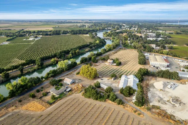 an aerial view of ocean and residential houses with outdoor space